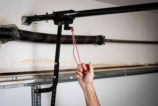 Person pulling garage door emergency release cord